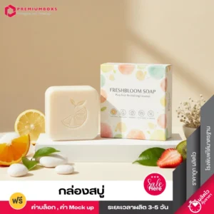 กล่องสบู่ สีขาวพร้อมพิมพ์โลโก้และลวดลาย และก้อนสบู่วิตามิน สกินแคร์ วางอยู่บนแท่นสีขาว