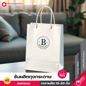 สกรีนถุงกระดาษ สีขาว ดีไซน์เรียบง่าย แนวมินิมอล พร้อมพิมพ์โลโก้ตัว B วางอยู่บนโต๊ะสีน้ำตาล